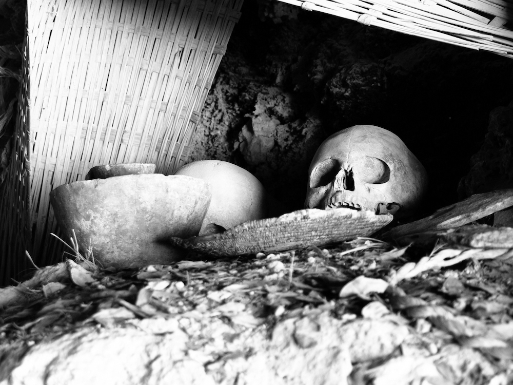Human skull with liturgical objects in the grave. Black and white image.